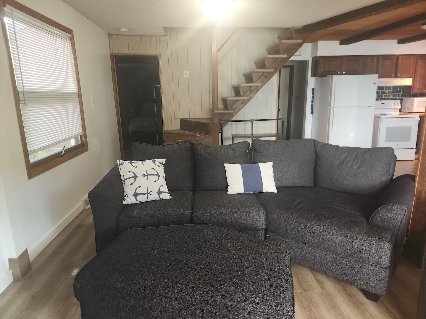 Main living room with lake-facing windows and a large sectional